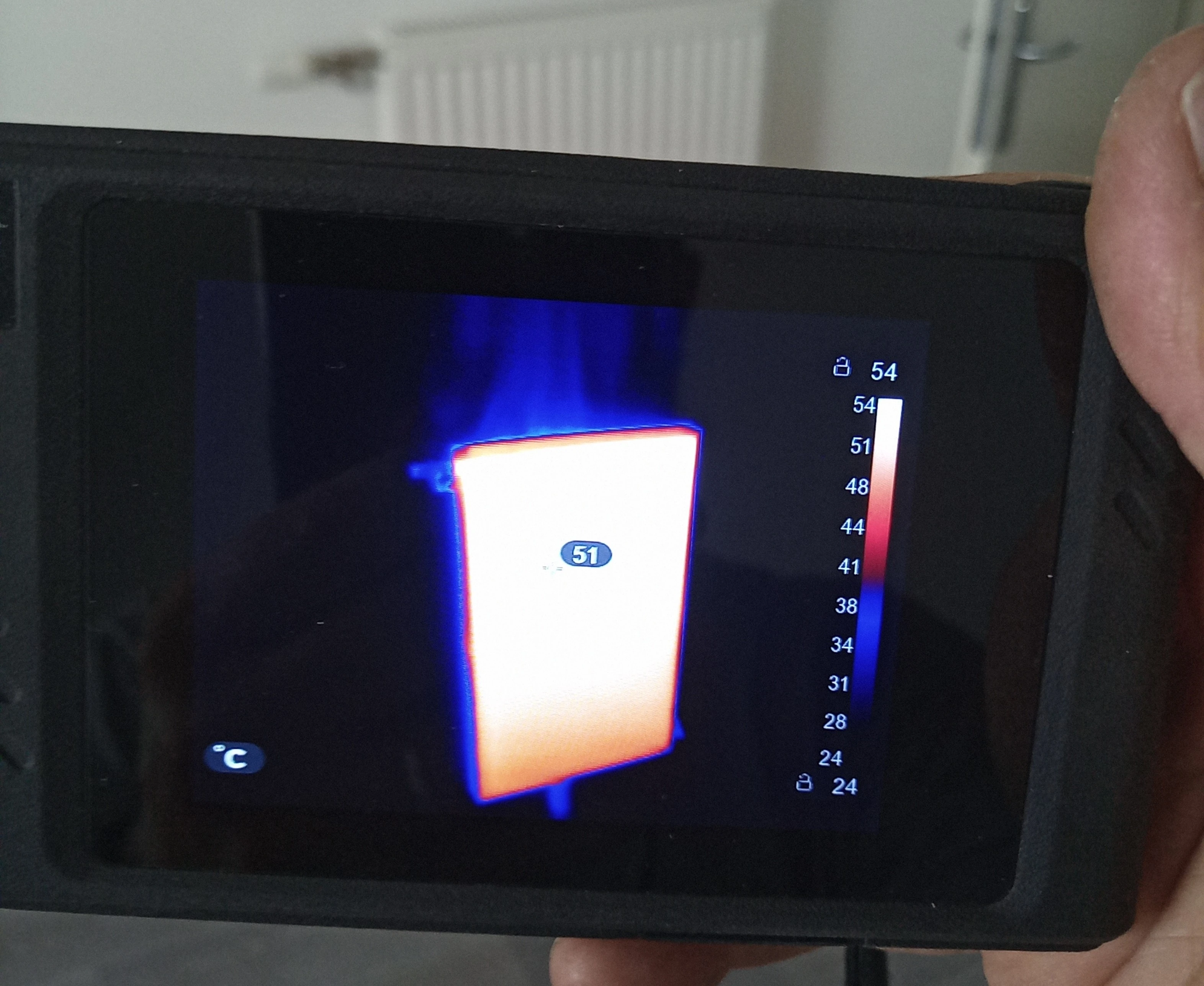 Machine de désembouage raccordée sur un radiateur pendant le nettoyage du circuit